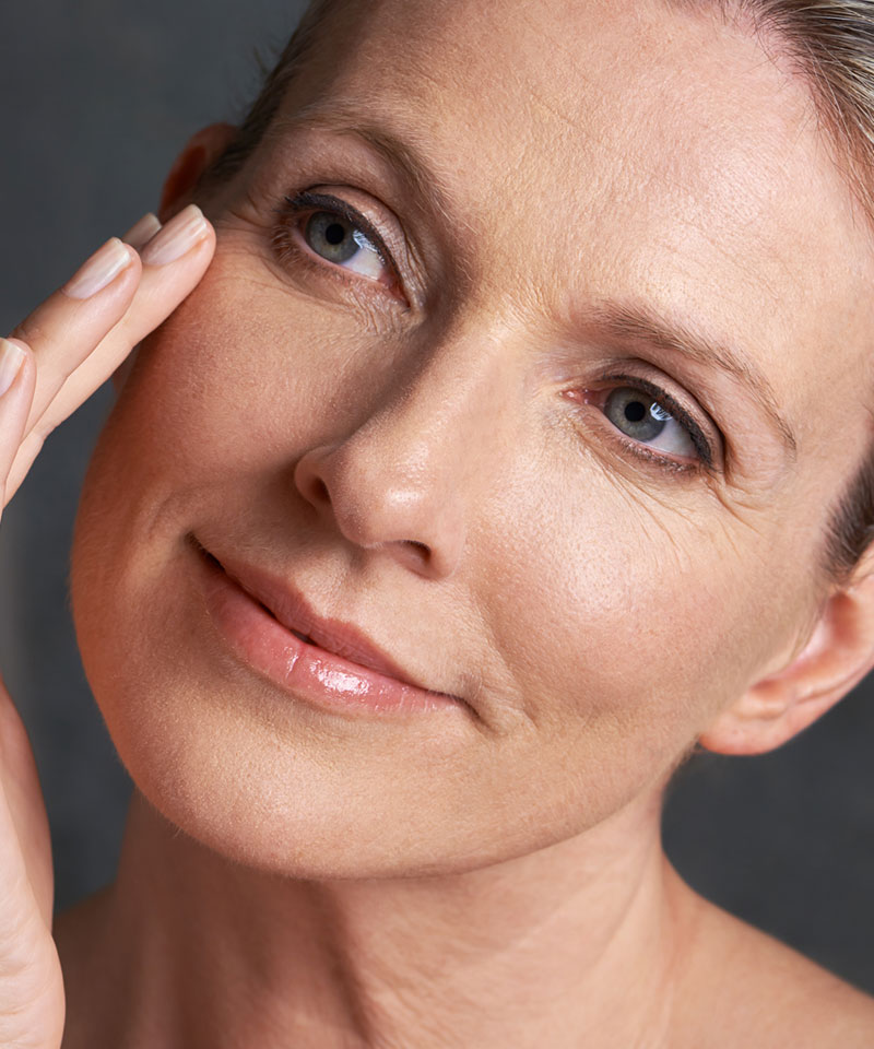 Red haired woman with blue eyes and brilliant skin close up. Dr. Costa non surgical procedures Las Vegas